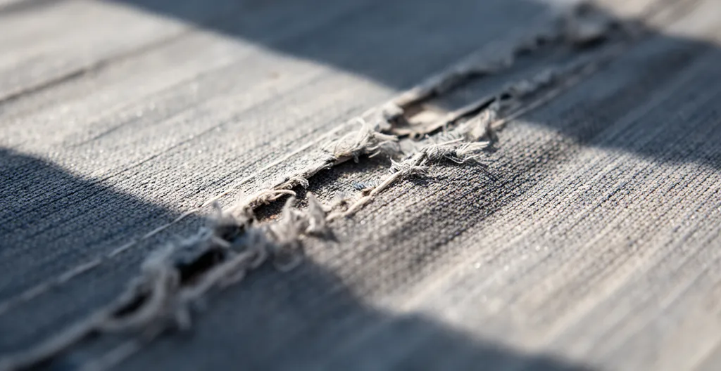 Toile de store banne décolorée par les UV montrant l'usure prématurée